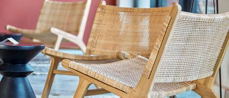 Wicker lounge chairs with a woven seat and backrest, arranged on a patterned rug.