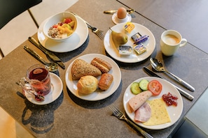 A breakfast setting with plates of food, a cup of coffee, and cutlery. - ibis budget Bayreuth (Bayreuth)