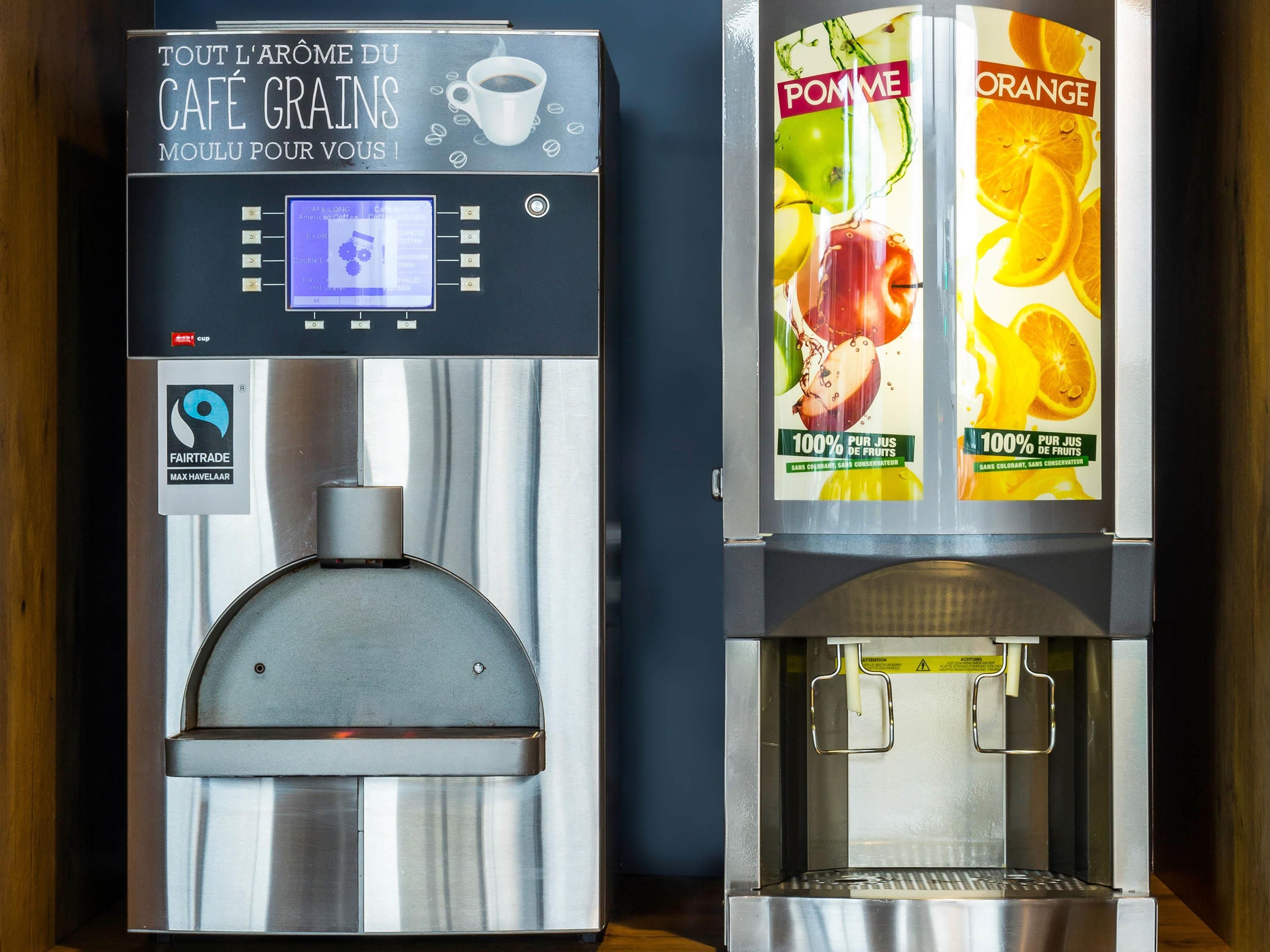 Deux distributeurs de boissons, l’un pour le café et l’autre pour les jus de fruits, portant la mention « Commerce équitable ».