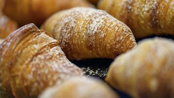Primer plano de varios croissants cubiertos de azúcar glas.