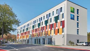 Un moderno edificio de hotel con varios pisos, ventanas amplias y techo plano.