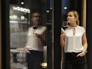 A person holding a wine glass, standing in front of a reflective surface. - ibis Styles Bayreuth (Bayreuth)