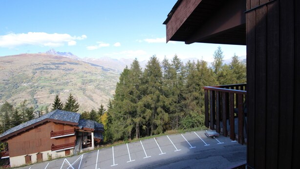 Vista de la montaña desde un edificio de madera con estacionamiento.
