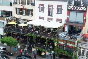 Ein lebhaftes Straßencafé mit mehreren Sitzbereichen und einem Restaurant.