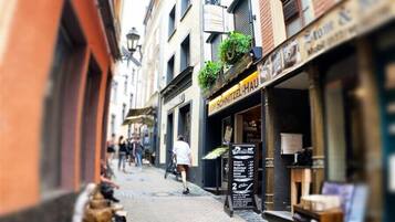 A narrow street with buildings on either side, a sign for 'Equilibra Schlesien', and a shop named 'SCHRITZEL-HAU'.