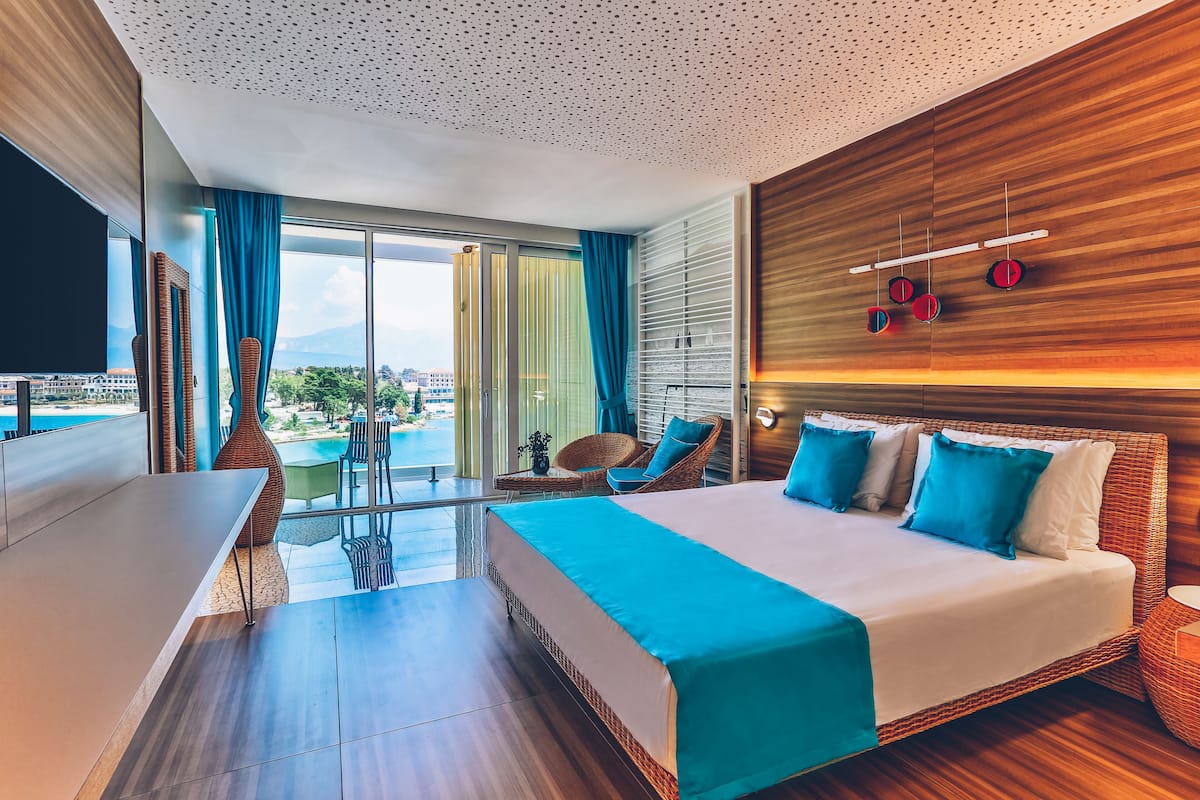 Une chambre d’hôtel moderne dotée d’un grand lit, d’une table à manger et offrant une vue sur la ville.