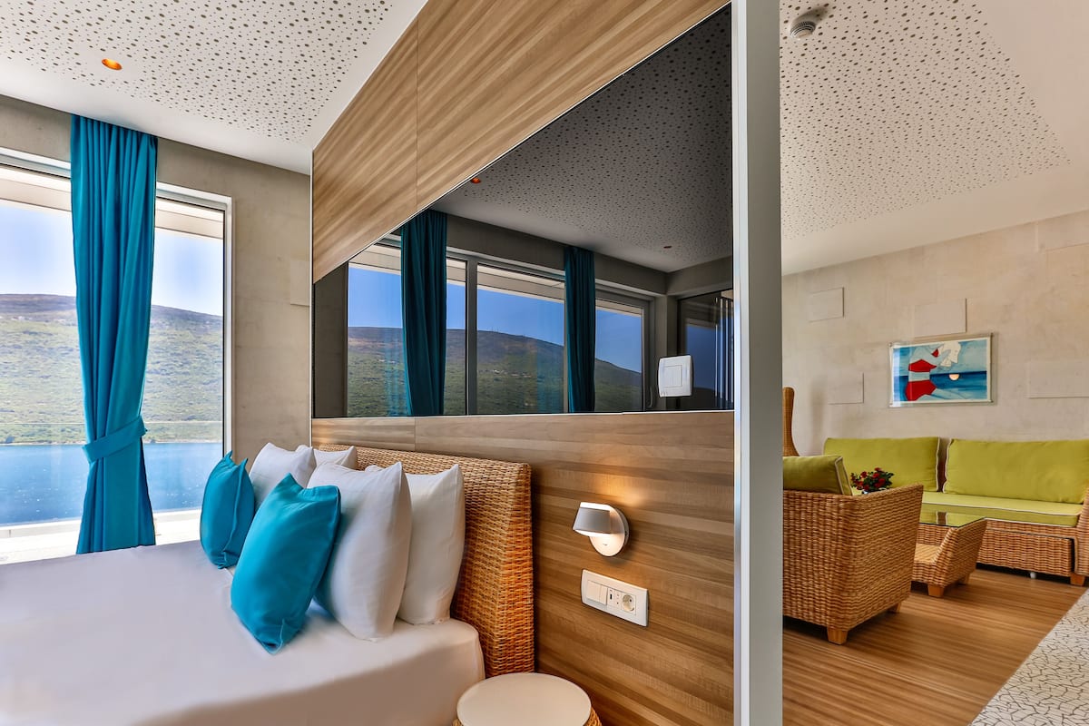 Une chambre d’hôtel moderne dotée d’un grand lit, d’un canapé et offrant une vue sur le paysage.