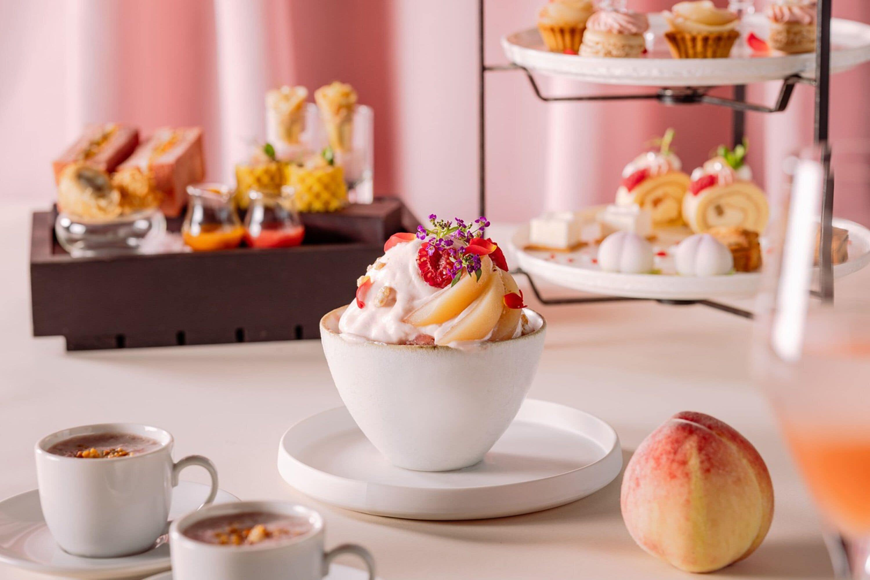 A dessert table with various pastries and a peach.