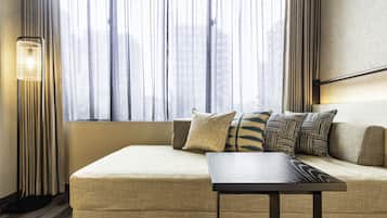 A modern room with a sofa, a side table, and a floor lamp.