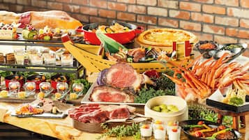 A buffet table with various food items including meats, seafood, and desserts.