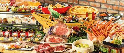 Una mesa de buffet con diversos alimentos, incluyendo carnes, mariscos y postres.