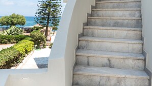 A staircase leading to a building with a view of the sea. - Musela Studios (Rethymno)