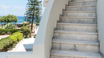 A staircase leading to a building with a view of the sea.