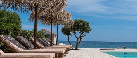 季节性开放的室外游泳池,池畔遮阳伞,日光浴躺椅
