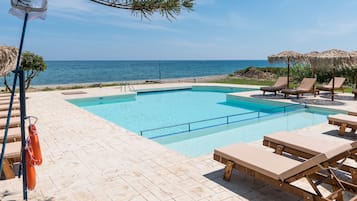 Una piscina al aire libre de temporada, sombrillas