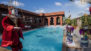 Un área de piscina con un edificio tradicional al fondo.