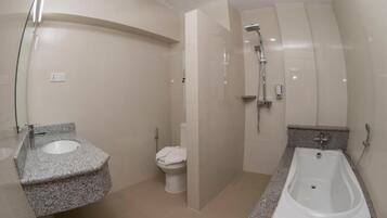 A modern bathroom with a granite countertop sink, a white toilet, a shower area, and a bathtub.