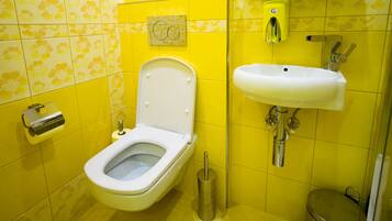 A bathroom with a toilet, bidet, and sink.