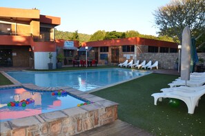 Una piscina al aire libre, tumbonas