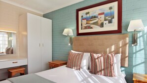 A bedroom with a bed, a nightstand, a dresser, and a painting on the wall. - Baywater Village (Sedgefield)
