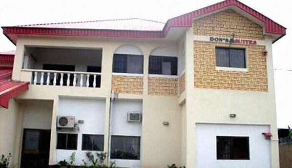 A two-story building with a sign reading "DON'S BUTTIES" on the upper floor. - The Don's Suites (Calabar)