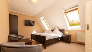 Ein Schlafzimmer mit Bett, Nachttisch, Stuhl und einem Fenster mit Blick.