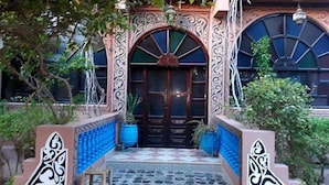 Un edificio con detalles arquitectónicos ornamentales, incluyendo una entrada decorativa con suelo de baldosas y una puerta central.