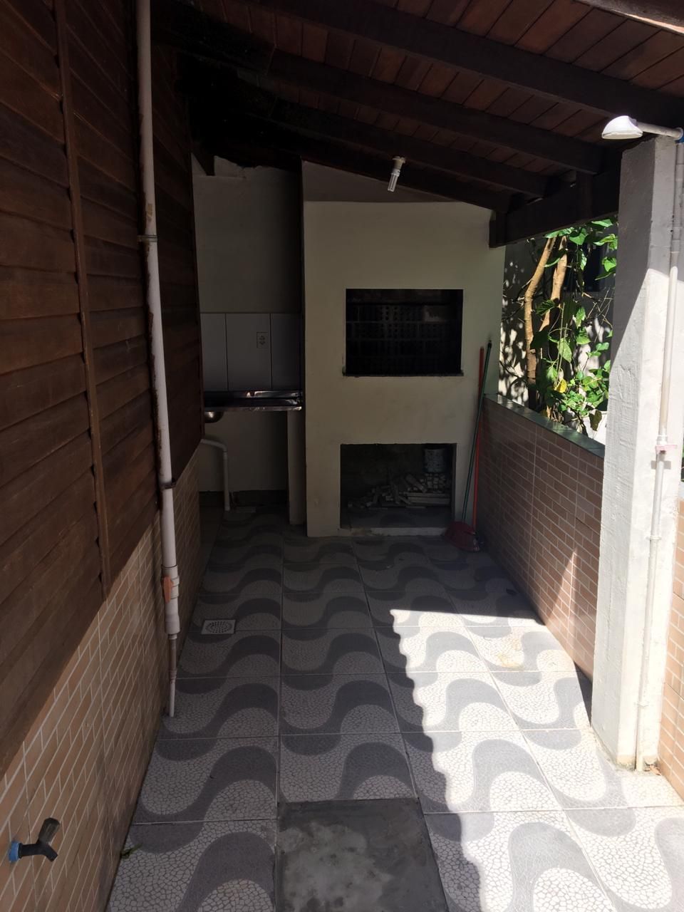 A narrow corridor with a tiled floor, a fireplace, and a window with bars.