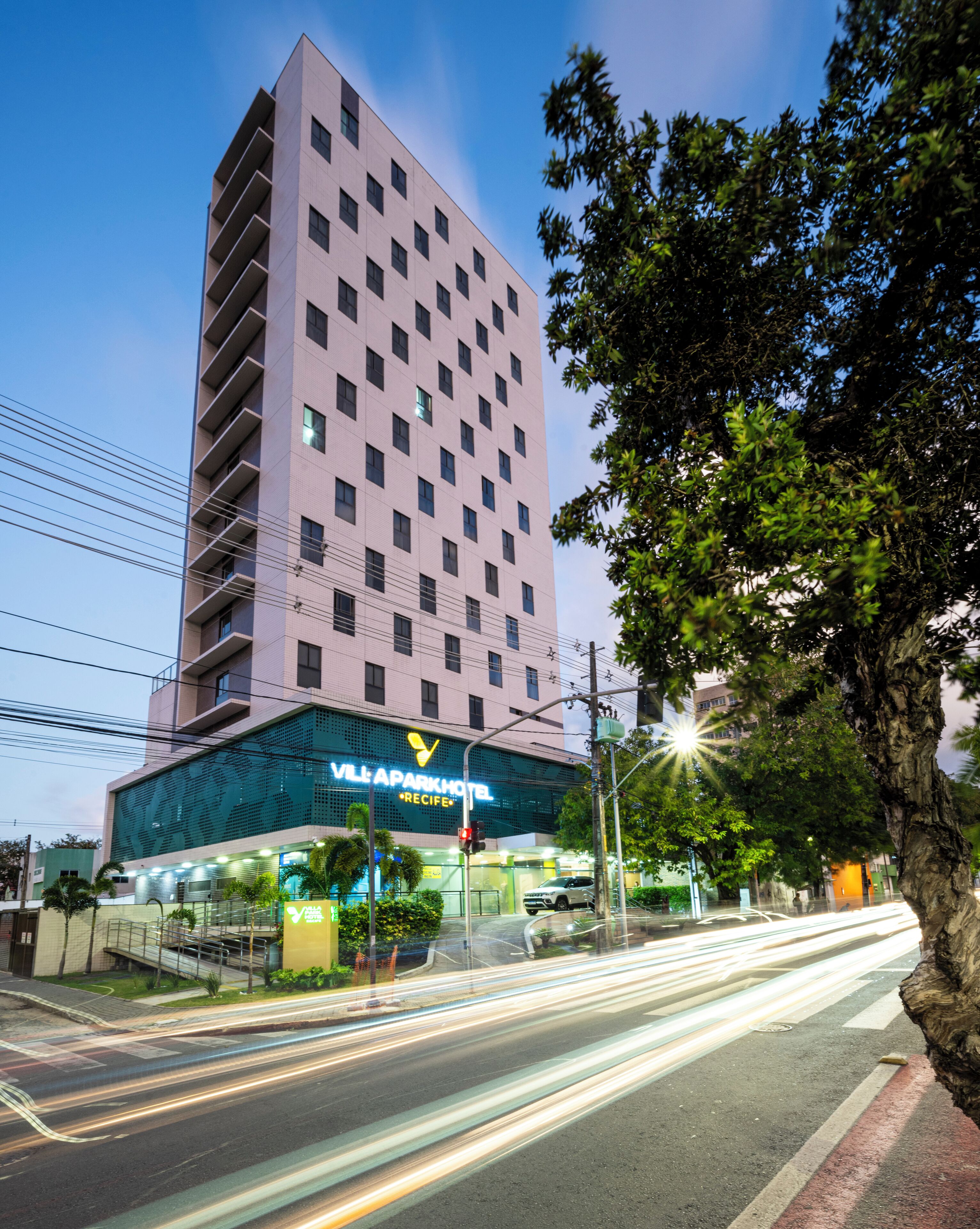 A modern hotel building with a prominent sign for "VILLAPARK HOTEL."