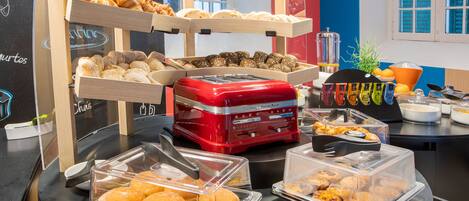 A breakfast buffet with various pastries and a coffee machine.