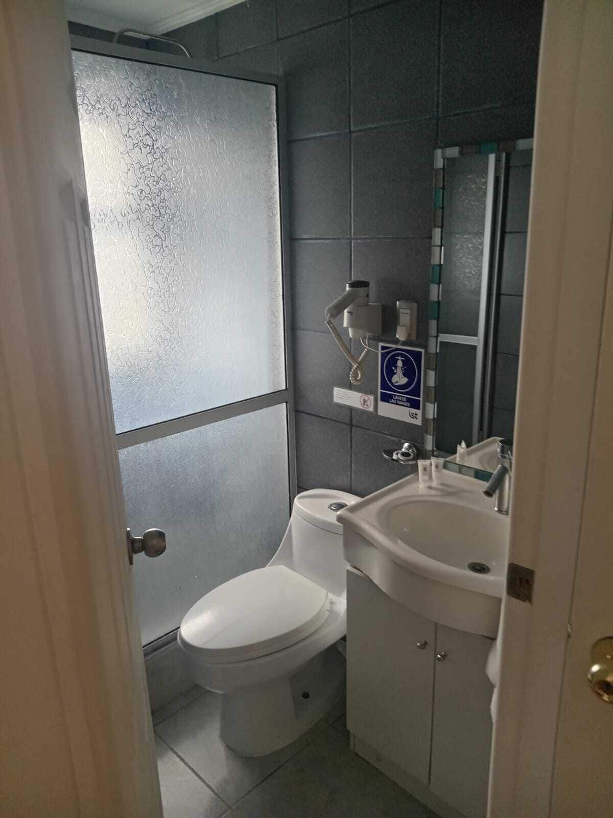 Une petite salle de bain avec des toilettes, un lavabo et un miroir.