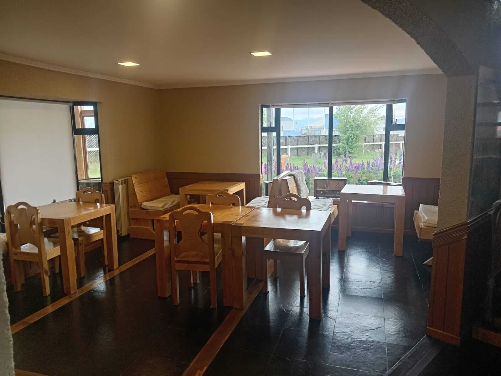 Una habitación con una mesa y sillas de madera, un sofá y una chimenea.