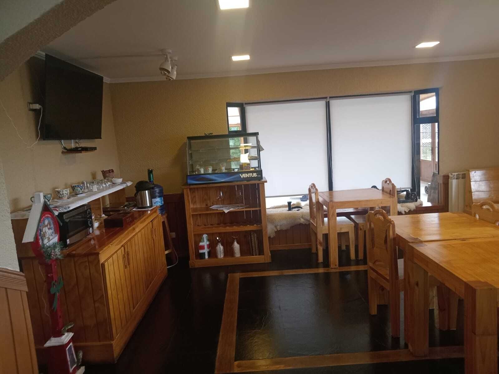 Una habitación acogedora con una mesa de madera, sillas, un acuario y un televisor en la pared.