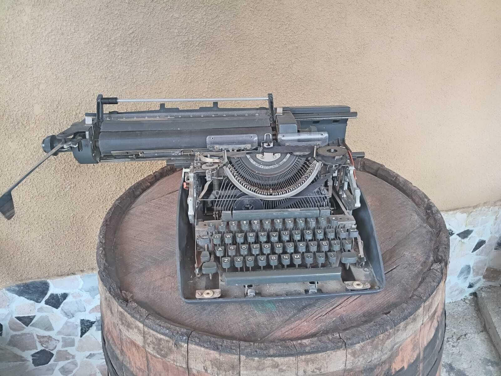 A vintage typewriter on a wooden barrel.
