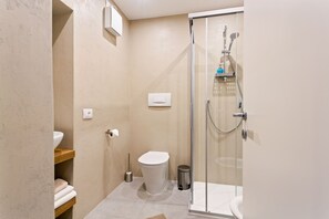 Appartement | Badkamer | Een douche, een haardroger, een bidet, handdoeken