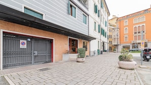 A courtyard with a gated entrance, potted plants, and a paved walkway. - Scrovegni Design Apartment (Padova)
