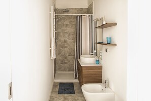 A modern bathroom with a shower, a bathtub, a sink, and a vanity. - Piazza dei Frutti Flat (Padova)