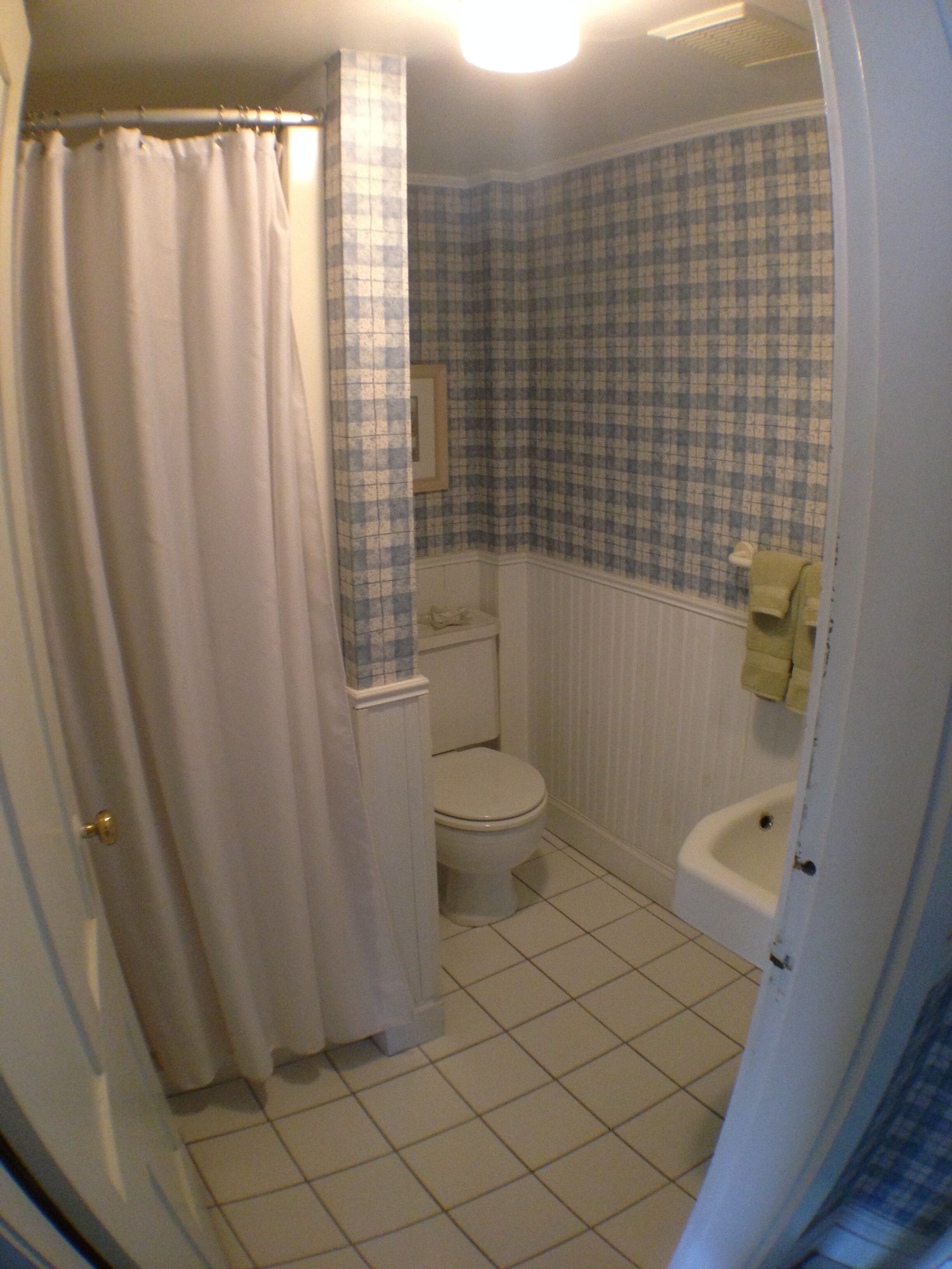 A bathroom with a toilet, sink, and bathtub.