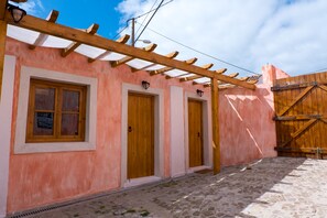A pink building with wooden doors and a wooden pergola. - Terra Lodge (Mafra)