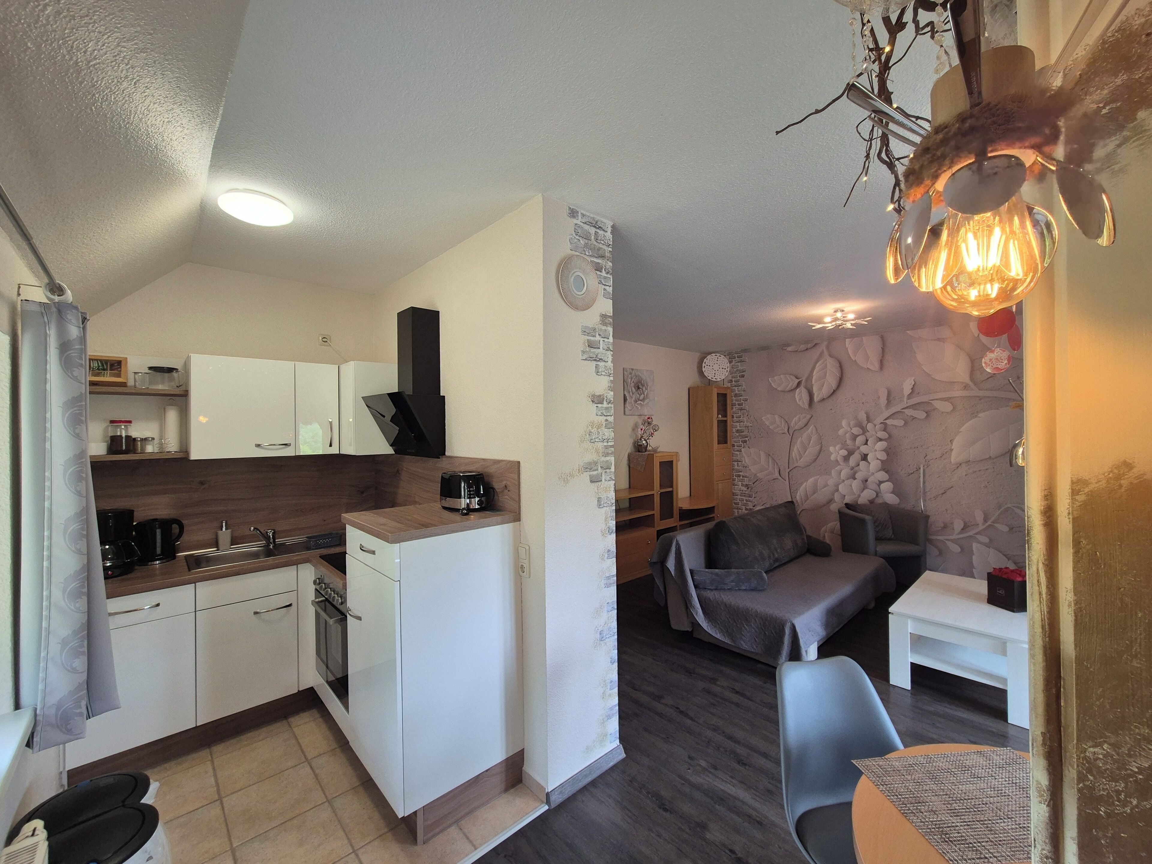 A compact kitchen with white cabinets, a built-in oven, and a coffee maker.