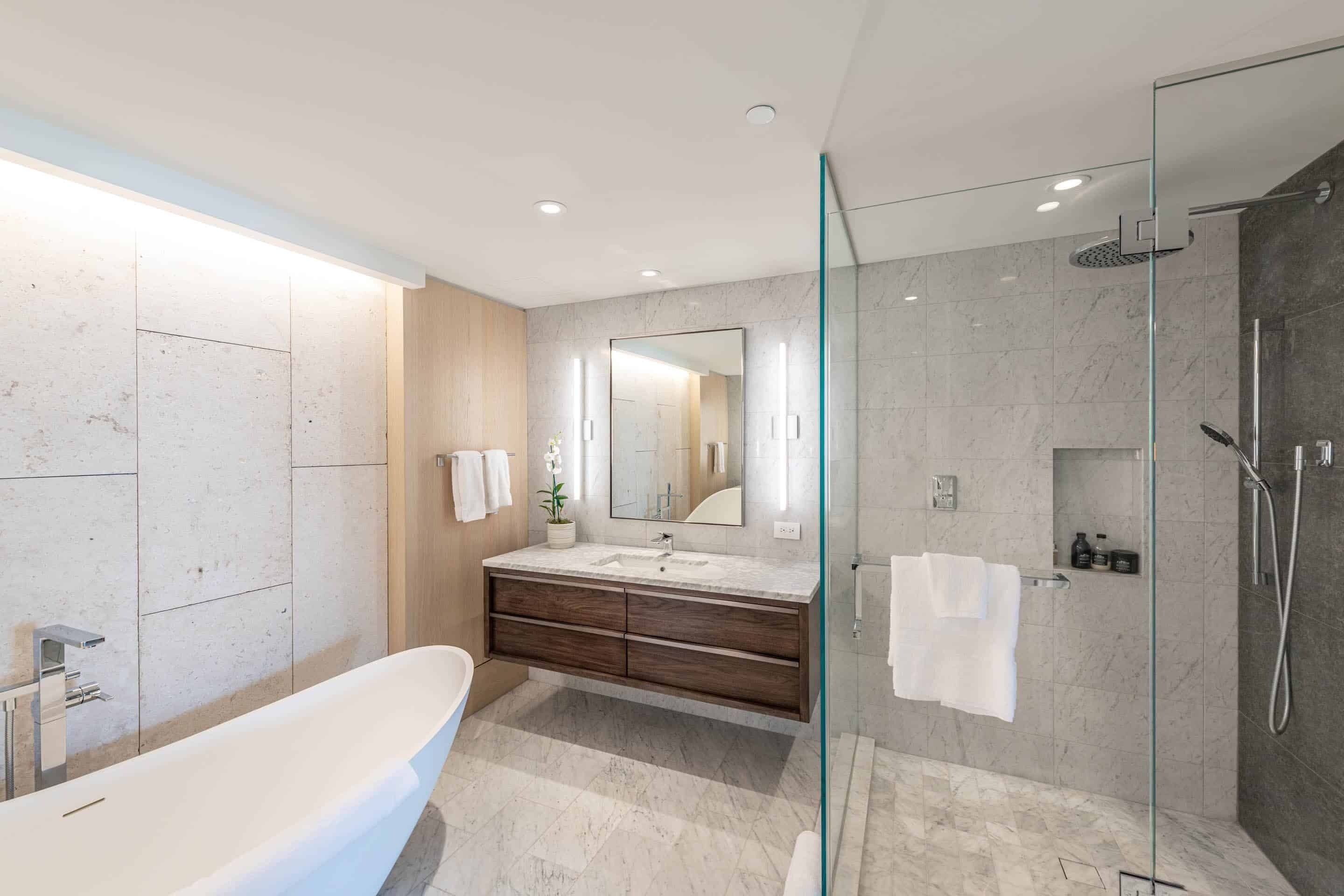 Une salle de bain moderne avec une baignoire sur pieds, une douche à parois de verre et un meuble-lavabo avec un miroir.
