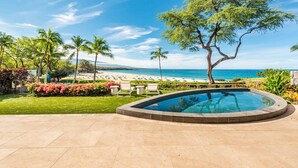A pool area with a view of the beach and ocean.