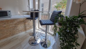 A modern kitchen with a microwave, a stainless steel bar stool, and a potted plant. - Srecko Centar Apartment (Belgrade)