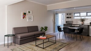 A modern living room with a sofa, coffee table, and artwork on the wall.
