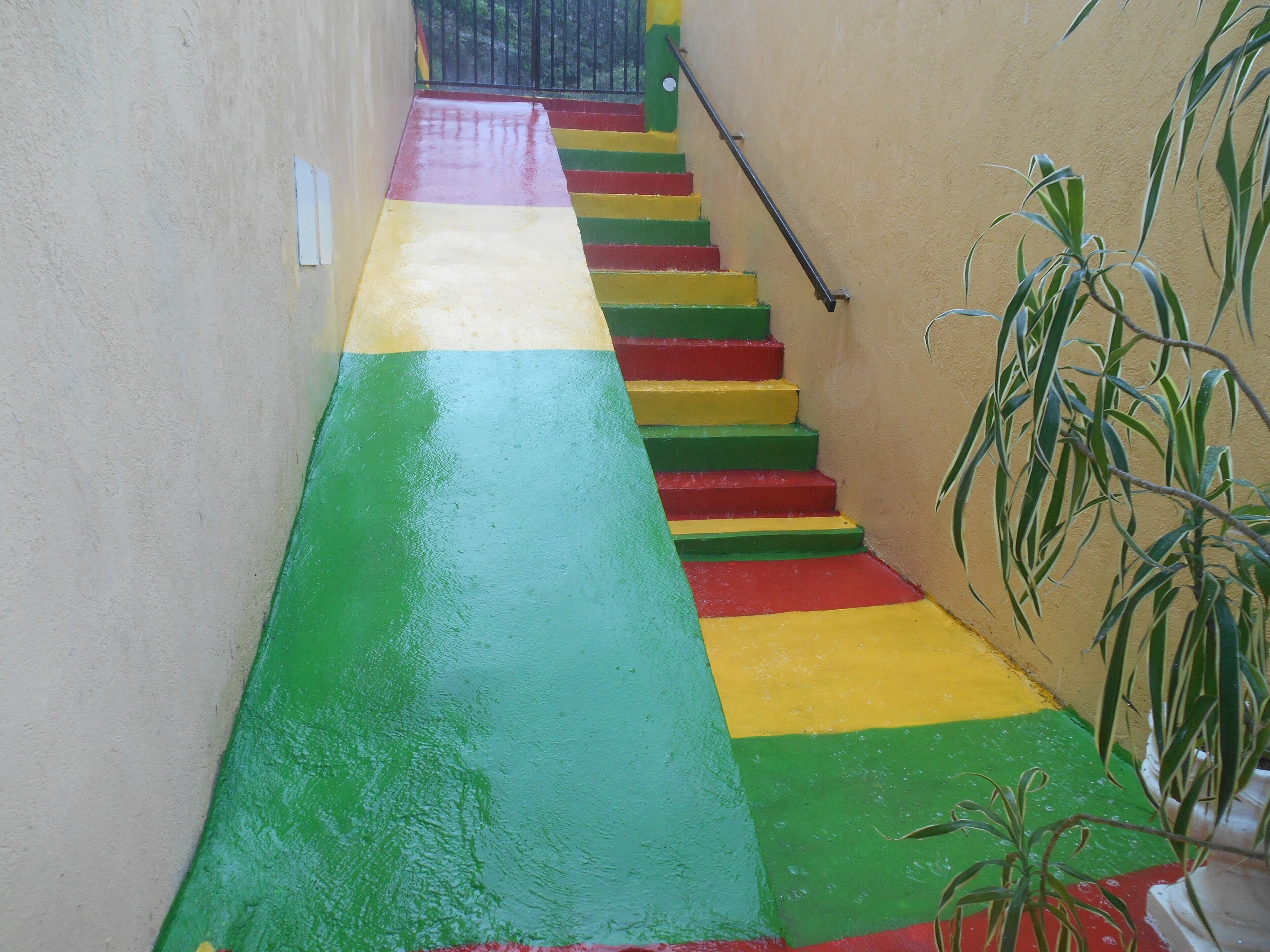 A staircase with alternating red, yellow, and green steps leading up to a door.