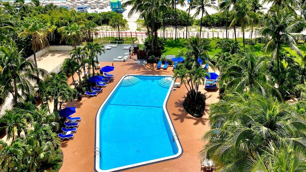 Un resort con piscina, playa y vista al océano.