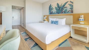 Una habitación de hotel con una cama grande, mesitas de noche, un escritorio y una silla.