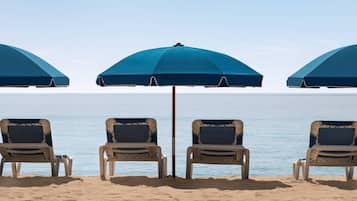 Aan het strand, ligstoelen aan het strand, parasols, strandlakens