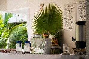 A kitchen counter with various containers, a coffee maker, and a menu board.