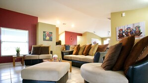 Un salon comprenant un canapé, deux fauteuils, une table basse et une petite table d’appoint sur laquelle est posée une plante.